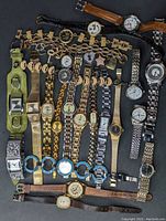 Top view of all 21 assorted ladies watches with various strap materials and styles.