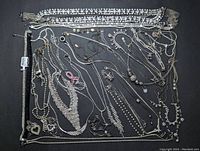 Top-down view of the collection of silver tone rhinestone necklaces with one set including matching bracelet and earrings.