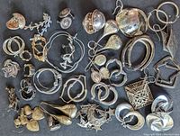 Full overview of the lot with various shapes of sterling silver earrings arranged closely