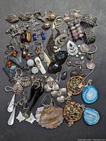 Top view showing full assortment of 34 pairs of earrings including sterling silver with various stones and art glass, all hallmarked