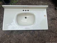 Image of white sink top showing integrated basin, faucet holes, and overall shape