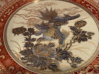Close-up of interior central motif showing mythic beast in gold and blue atop crackled surface