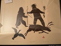 Framed print showing entire composition of two Inuit figures and caribou on cream background