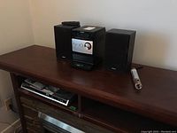 Sony Micro Hi-Fi Component System with two Sony speakers and remote control on top, Panasonic DVD/CD player below, flashlight on the right side.