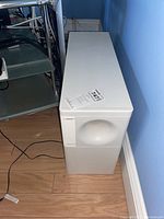 White Bose subwoofer cabinet positioned on floor