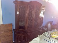 Full view of Ethan Allen lighted china cabinet with glass panel doors and wooden drawers below.