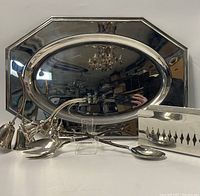 Photo showing the octagonal stainless steel serving tray, reticulated napkin holder, and metal tongs displayed together