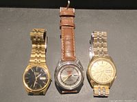 Front view of three men's Seiko automatic watches showing black, silver, and beige dials, metal and leather bands.