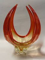 Front view of orange-to-clear freeform glass bowl on white background.