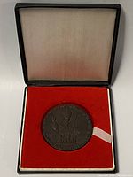 Medallion inside original presentation box with red fabric interior.