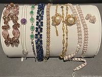 Bracelets and earrings displayed on white jewelry holder, showing variety of colors and materials