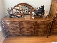 Front view of dresser and mirror with decorative model ships on top