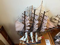 Four wooden model ships shown together on a flat surface.