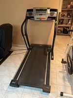 Full front view of treadmill showing running deck, handrails and console
