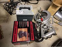 Overall photo showing all three items: the Skil circular saw, Craftsman finishing sander in box, and Lester battery charger.