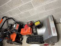 Side view of snow blower showing track drive, chute, and body