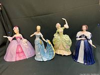 Front view showing four hand-painted porcelain figurines in period dresses, colors pink, lavender, blue, green, and blue-white