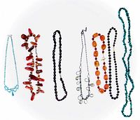 Photo showing seven costume jewelry necklaces of varied styles and stones laid out horizontally on a white background.