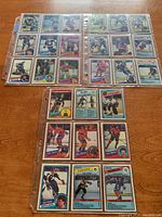 Photo of multiple hockey cards arranged in sleeves showing front of cards including player portraits and action images