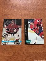 Two Canadiens hockey cards side by side on a wooden surface, showing Patrick Roy in goalie gear and Russ Courtnall skating with a stick.