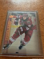 Front angled view of Daniel Carcillo Young Stars rookie card in protective sleeve with visible gold foil and Arizona Coyotes uniform.