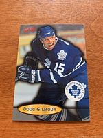 Front view of the 1996-97 Fleer Doug Gilmour hockey card showing the player in action wearing Toronto Maple Leafs jersey number 15.