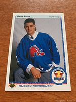 Front side of the 1990/91 Upper Deck Owen Nolan rookie card showing player photo in Quebec Nordiques jersey and draft emblem.