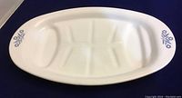 Top view of the white oval Corning Ware platter with blue cornflower pattern on each end, showing overall condition and design.