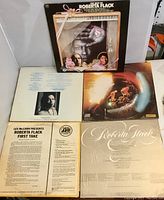 Top view of four Roberta Flack LP cover backs and one front cover visible, showing listing of tracks and album details, illustrating condition and completeness.