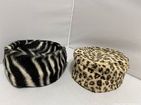 Both vintage pillbox hats side by side showing animal prints and overall shapes.