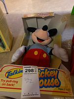 Playskool Talking Mickey Mouse plush in original yellow box showing front with talking feature info and some wear on box edges.