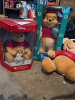 Three Winnie the Pooh bears displayed, including boxed Christmas themed bears and a loose plush.