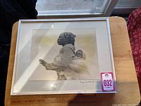 Full view of framed black and white photograph depicting Zulu woman carrying child, signed by Doug Sheldrick.