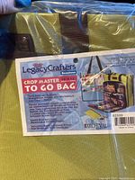 Close-up of the product label showing 'Legacy Crafters Crop Master To Go Bag' with details about dimensions and features