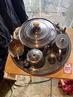 View of entire silver plated tea and serving set on round tray showing tarnish and wooden handles