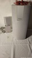 Front view of 2 stereo satellite speakers and 1 larger subwoofer speaker, all in white with Panasonic logo on front.