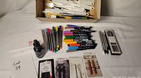 Full assortment including boxed soft pastels, black ink bottle, colorful markers, and brushes loosely arranged