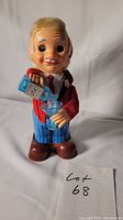 Front view of the Blushing Willy animated bartender toy showing face, hair, and held martini glass and shaker