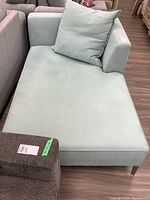 Side view of light green micro suede lounger sofa with oversized cushion, showing general shape and condition.