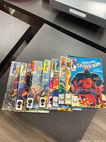 Overhead view of full lot fanned out on table showing multiple Amazing Spider-Man covers