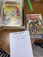 Stack of Avengers comics in protective sleeves, front cover of issue #56 with Spider-Man cameo visible