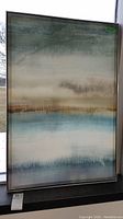 Full view of metal framed abstract print showing colors and frame.