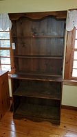 Full view of wooden bookcase with five shelves, showing condition and shape