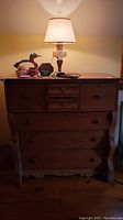 Front view of dresser with lamp and decorative items on top