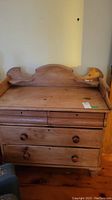 Full front view of dresser showing four drawers, wooden knob pulls, and gallery back.
