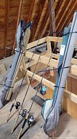 Three rods and rod bags leaned against attic rafters showing overall lot