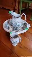 Overall view of the vintage ceramic wash basin and jug set with a small jug, showing detailed floral pattern and shape of each piece.