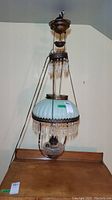 Full view of hanging lamp showing top canopy, chains, shade, prisms and reservoir