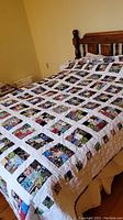 Quilt spread out on bed showing front patchwork design with multiple multicolored fabric squares bordered by white strips.