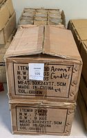 Box containing multiple green glass jar candles with lids, cardboard packaging with weight and dimension labels